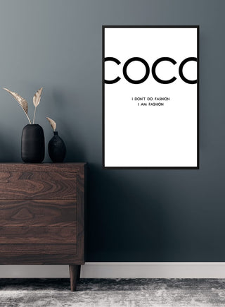 Minimalist black-and-white Coco Chanel poster with fashion quote, displayed above a modern wooden dresser.