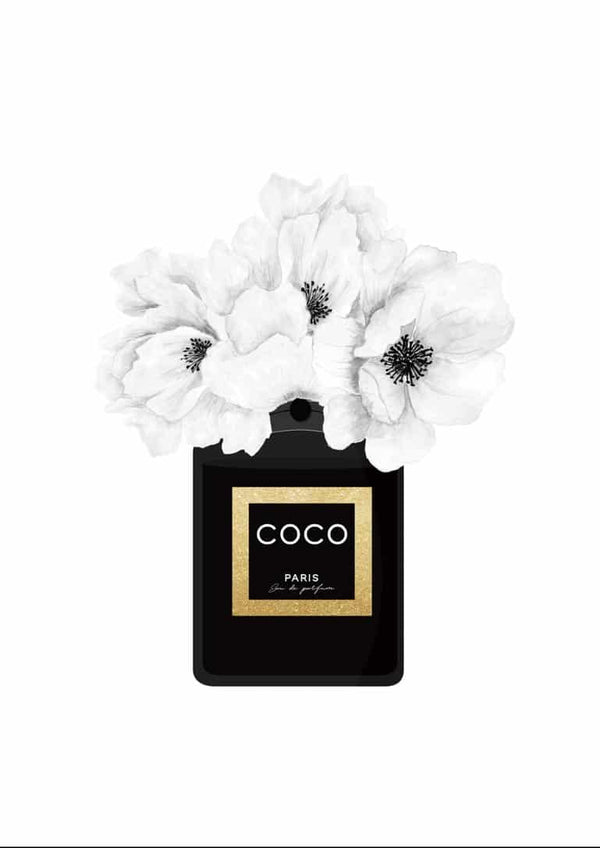 Black Chanel perfume bottle with white flowers blooming from the top, Coco Paris label in gold and black.
