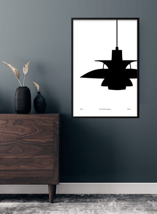 Poster of Poul Henningsen's PH5 lamp hanging on a dark wall above a wooden dresser in a modern living room.