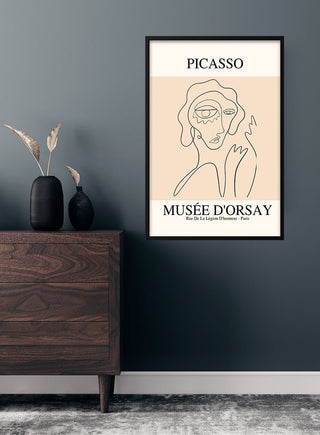 Minimalist Picasso-inspired women poster with abstract face line art, displayed above a wooden dresser.