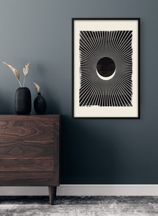 Framed Solformørkelse Plakat featuring a stylized solar eclipse hangs above a dark wooden dresser.