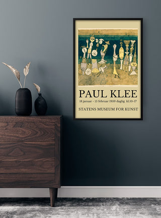 Framed Paul Klee Exhibition 1959 poster displayed on a dark wall above a wooden dresser with decorative vases.