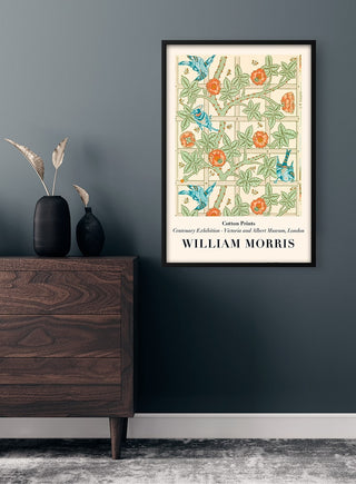 Framed William Morris Trellis Plakat with floral and bird design hanging on a dark wall above a wooden cabinet.