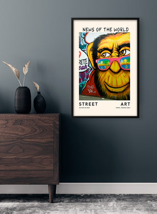 Framed "News of the World" street art print featuring a colorful chimpanzee with vibrant glasses on a wall.