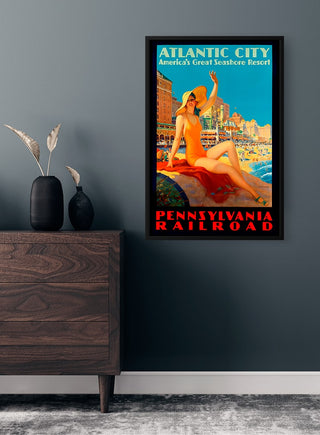 Framed Atlantic City vintage travel poster featuring a sunbathing woman on a beach, displayed on a modern wall.