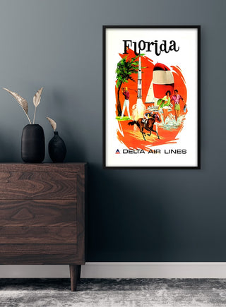 Framed Florida Vintage Plakat on a dark wall above a wooden dresser with vases and dried plants.