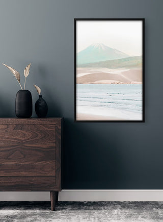 Framed Mountain and Beach Plakat art on a dark wall above a wooden dresser with minimalist decor.