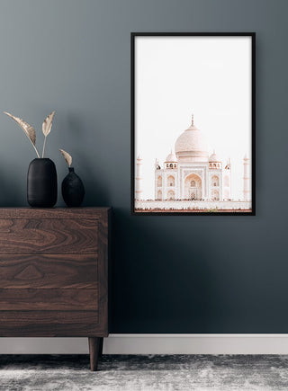 Framed Taj Mahal poster hanging above a wooden dresser in a modern, minimalist room.