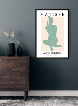 Framed Matisse Inspired Green Decoupe Plakat with abstract figure on a wall above a wooden dresser.