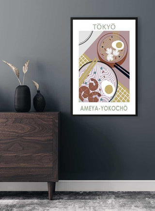 Framed Tokyo ramen poster with modern illustration of two ramen bowls, displayed above a wooden dresser.