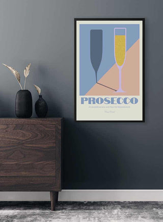 Minimalist Prosecco poster with two glasses, one filled and one empty, on a wall above a wooden dresser.