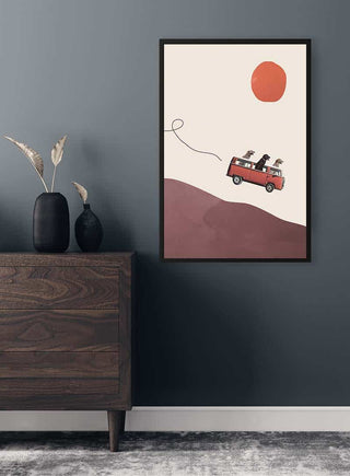 Framed "Adventure gang" art by Maarten Léon featuring dogs in a red car under an orange sun, displayed on wall.
