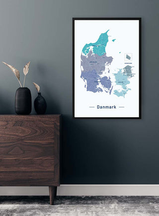Blå Danmarkskort Plakat displayed on a wall above a wooden dresser in a modern, minimalist room.