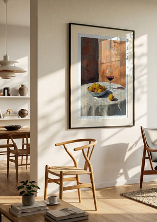 Summer scene: Lemons and wine by Ohkimiko in a black frame in a bright dining room with wooden chairs