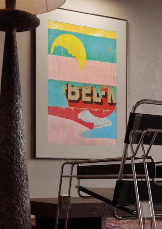 BEL-M by Kareem Rizk framed in a dim room beside a tubular steel chair