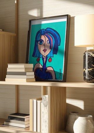 Lady Kontrast by Trude in a dark frame on a wooden shelf beside books and a lamp