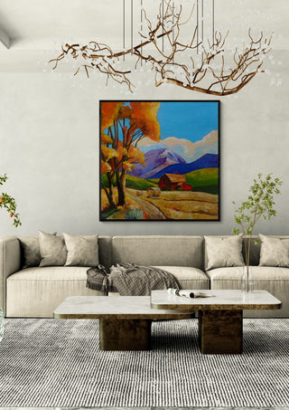 Autumn Fields by Evgenia Smirnova in a black frame above a cream sofa under a branch chandelier