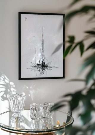 Two Masts by Justyna Kopania in a black frame above a glass table with crystal glassware