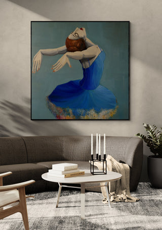 Ballerina in Blue by Justyna Kopania in a black frame above a dark sofa with candlesticks on a round table