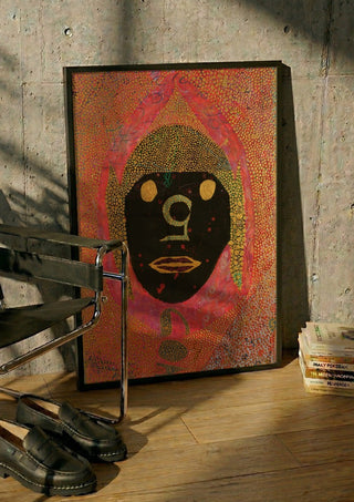 GOA by Ali Kasap in a black frame leaning against a concrete wall by a steel chair