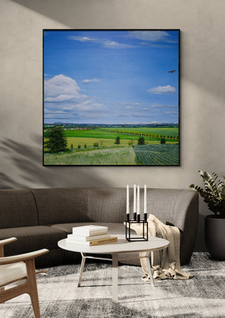 Uhlenhoch - East Germany by Juergen Duerrmann in a black frame above a dark sofa with candlesticks on a round table