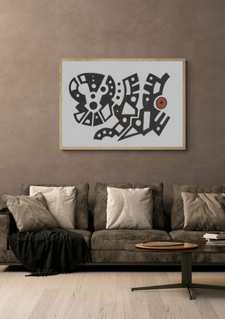 Black and White Glyphs by John Larkin in a light oak frame above a grey sofa on a warm brown wall
