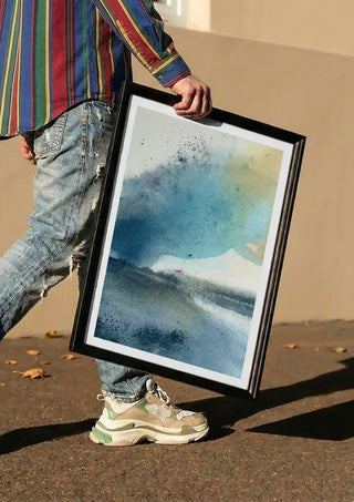Blue October by Tania Zubareva carried in a black frame along a sunny street