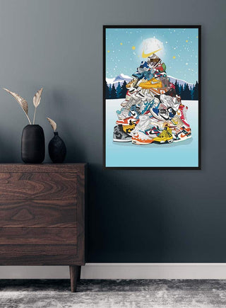 Framed art of a Christmas tree made from Airforce sneakers, displayed on a wall above a wooden dresser.