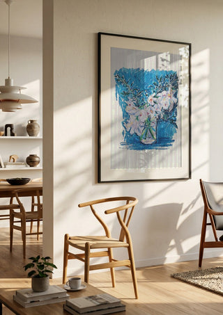 White Blooms on Blue by DNF in a black frame in a bright dining room with wooden chairs