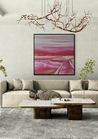 Pink Winter by Emil Walli in a black frame above a pale sofa under a branch chandelier