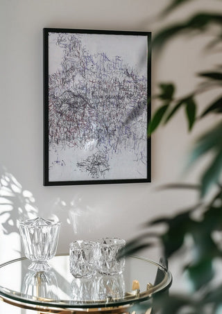 Nike by Priit Ruttas in a black frame above a glass table with crystal glassware