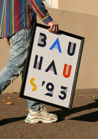 Bauhaus Letters by Neil Stevens carried in a black frame along a sunny street