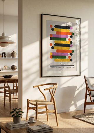 Bauhaus Stacks by Neil Stevens in a black frame in a bright dining room with wooden chairs