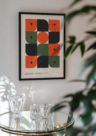 Bauhaus Forms 1923 by Neil Stevens in a black frame above a glass table with crystal glassware