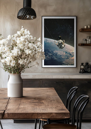 Swing by Fran Rodriguez in a black frame above a rustic table with white flowers