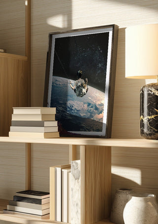 Swing by Fran Rodriguez in a dark frame on a wooden shelf beside books and a lamp