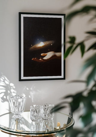 Supernova by Fran Rodriguez in a black frame above a glass table with crystal glassware