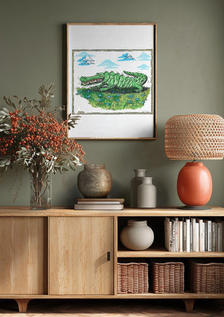The Crocodile and the Book by Waldemar Mandzel above a wooden sideboard on a sage green wall