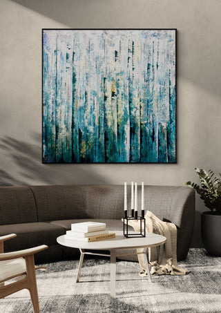 Teal Abstract by Marina Agre in a black frame above a dark grey sofa with a round table and candlesticks