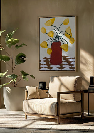 Gula blomster i terracottafärgad vas by Rebecka Hansson framed above a beige armchair beside a potted plant