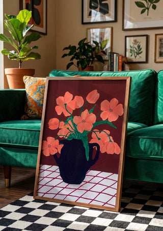 Rosa blomster på rutig duk by Rebecka Hansson in a wooden frame leaning against a green velvet sofa on a chequered floor