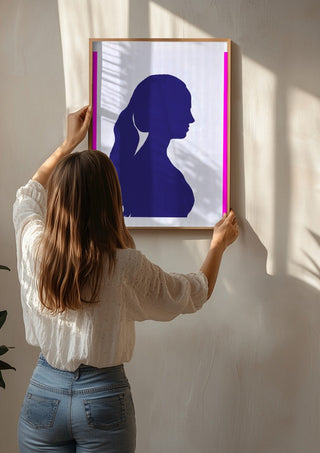 Femininity by Tonia being hung on a sunlit wall