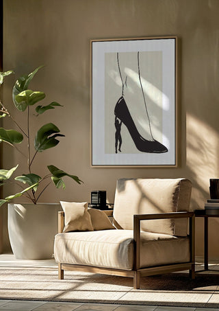 Heavy is the Heel by Nari framed above a beige armchair beside a potted plant