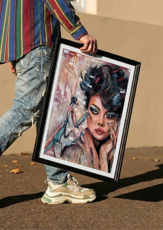 Die Göttin in dir by Elisa Kay carried in a black frame along a sunny street