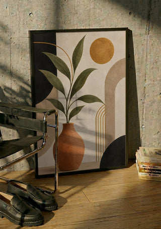 Terracotta Vase with Green Leaves by TimlessArtworks in a black frame leaning against a concrete wall by a steel chair