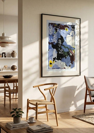 LOVE IS A DOG FROM HELL by Oscar Birch in a black frame in a bright dining room with wooden chairs