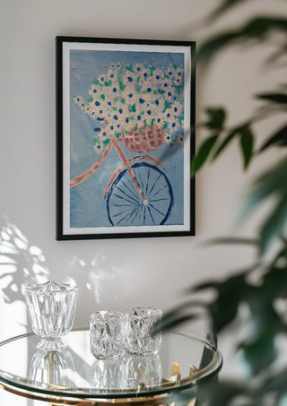 Whimsical Journey in White by Bibi in a black frame above a glass table with crystal glassware