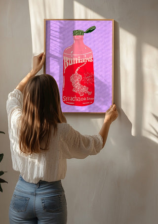 Sriracha chili sauce by Astrid Lind being hung on a sunlit wall