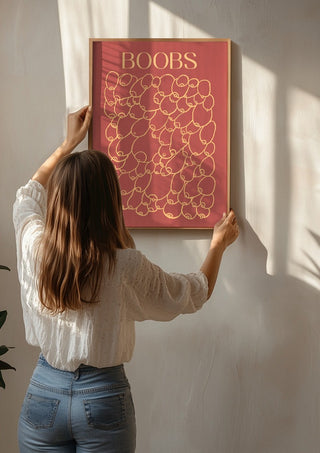 Boobs by Astrid Lind being hung on a sunlit wall