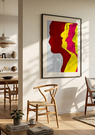 Genesis by Tonia in a black frame in a bright dining room with wooden chairs